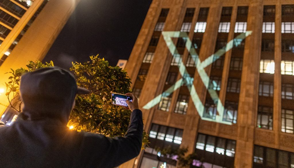 Twitter's new logo is seen projected on the corporate headquarters building in downtown San Francisco, California